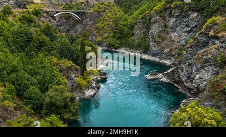 L'acqua turchese nel fiume Kawarau che scorre attraverso la gola e sotto il ponte stradale in cemento Foto Stock