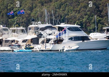 Yacht di lusso a motore Cruiser ha raziato su Pittwater Sydney il giorno 2023 Australia con bandiere australiane che volano patriottismo, NSW, Australia Foto Stock