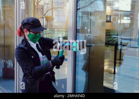 Londra, Regno Unito. Aprile 7, 2021. 7 estinzione le donne attiviste della ribellione rompono le finestre del quartier generale della Barclays Bank per condannare l’incapacità della banca di mantenere la promessa di rispettare l’accordo sul clima di Parigi in un’azione che ricorda il movimento suffragette. Il gruppo aveva dei segnali che recavano “finestre rotte migliori delle promesse rotte” e “in caso di rottura del vetro di emergenza climatica”. Credit: Joao Daniel Pereira. Foto Stock