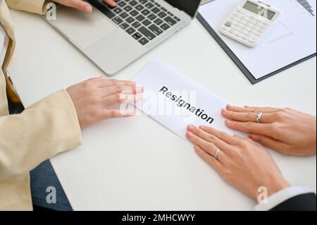 Una donna d'affari che invia una lettera di dimissioni al suo capo alla scrivania. rinunciare a un lavoro, disoccupazione, fallimento della carriera. primo piano immagine vista dall'alto Foto Stock