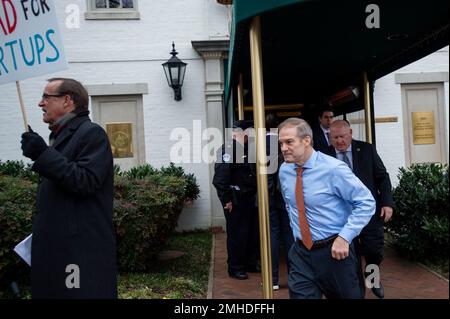 Washington, Stato di Vereinigte. 25th Jan, 2023. Mentre un uomo ha un cartello che protesta il Rappresentante degli Stati Uniti Darrell Issa (Repubblicano della California), il Rappresentante degli Stati Uniti Jim Jordan (Repubblicano dell'Ohio) lascia l'ufficio del Comitato Nazionale Repubblicano a Washington, DC, mercoledì 25 gennaio 2023. Credit: Rod Lammey/CNP/dpa/Alamy Live News Foto Stock