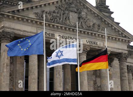 Berlino, Germania. 27th Jan, 2022. Le bandiere di Europa, Israele e Germania volano a mezza altezza di fronte all'edificio del Reichstag. La Giornata commemorativa dell'Olocausto, celebrata a livello internazionale il 27 gennaio, commemora la liberazione del campo di sterminio tedesco Auschwitz nel 1945. Credit: Wolfgang Kumm/dpa/Alamy Live News Foto Stock