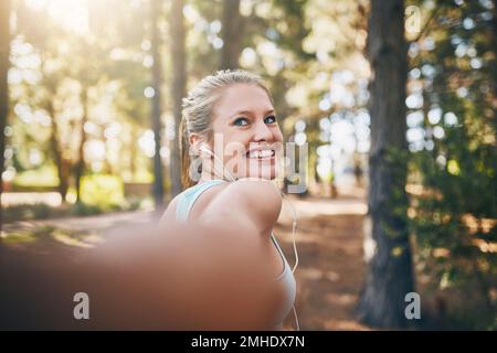 Centro fitness di destinazione. Prospettiva personale ripresa di una giovane coppia che cammina nella foresta. Foto Stock