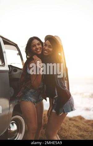 Che cosa è un viaggio di strada senza il vostro bestie. due giovani amici che si fermano in spiaggia durante il loro viaggio in auto. Foto Stock