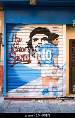 Un murale di fronte allo storefront del calciatore, la star del calcio Diego Maradona con il rivoluzionario che Guevera cubano. Un esempio di graffiti a Napoli, Napoli, Italia, IT Foto Stock