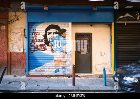 Un murale di fronte allo storefront del calciatore, la star del calcio Diego Maradona con il rivoluzionario che Guevera cubano. Un esempio di graffiti a Napoli, Napoli, Italia, IT Foto Stock