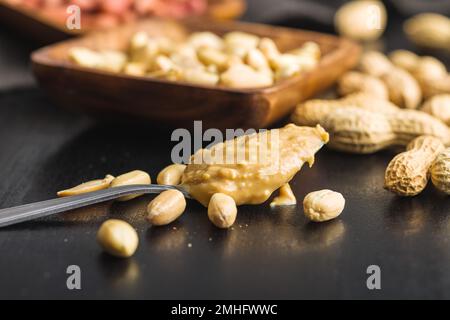 Burro di arachidi in cucchiaio sul tavolo da cucina. Foto Stock