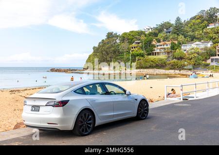 Auto elettrica Tesla modello 3 bianca, modello anno 2020, parcheggiata a Palm Beach a Sydney in un giorno estivo, Sydney, NSW, Australia Foto Stock