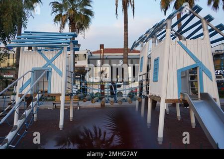 Parco giochi per bambini con strutture blu e bianche in clima caldo Foto Stock