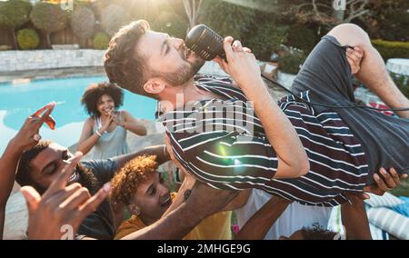 Microfono, canto e folla surfing con un uomo esecutore a una festa all'aperto durante l'estate. Concerto, energia e pubblico con un cantante maschile essere Foto Stock