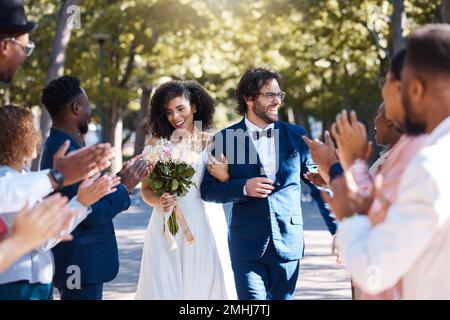 Felice celebrazione e clapping per la coppia al matrimonio con la folla entusiasta, allegra e allegra di ospiti. L'amore interrazziale e la collaborazione della gente a. Foto Stock