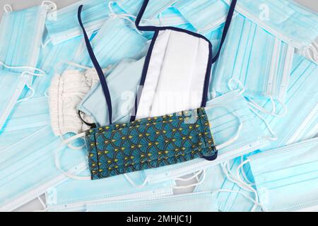 Coronavirus chirurgico di carta protettiva medica e mascherine in tessuto fatti in casa contro Coronavirus Covid in background vista dall'alto Foto Stock