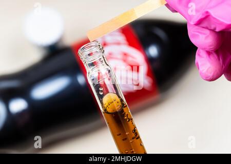 Mosca, Russia - 12 gennaio 2023: Misurazione del livello di pH della Coca Cola Classic, l'indicatore di tornasole rosa mostra l'acidità. Coca-Cola (Coca-Cola) è di carbonated Foto Stock