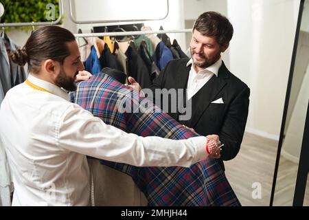 Cliente soddisfatto e designer di moda scegliendo il tessuto adatto per l'abbigliamento Foto Stock