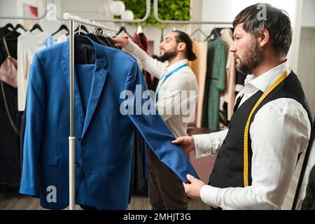 Stilisti esperti di moda che scelgono i vestiti per i loro clienti Foto Stock