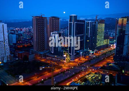 Paesaggio serale della città di Batumi con gli edifici in illuminazione serale. Foto Stock