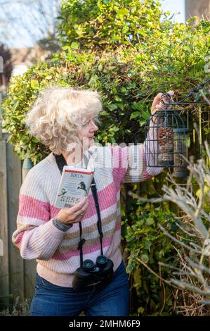 Brighton UK 27th gennaio 2023 - Un residente di Brighton mette fuori il cibo degli uccelli nel suo piccolo giardino urbano come lei prende parte a questo anno RSPB Big Garden Birdwatch questo fine settimana da Venerdì 27th gennaio a Domenica 29th gennaio . Ogni anno il grande orologio da giardino della RSPB aiuta a monitorare come gli uccelli si stanno fracchiando: Credit Simon Dack / Alamy Live News Foto Stock