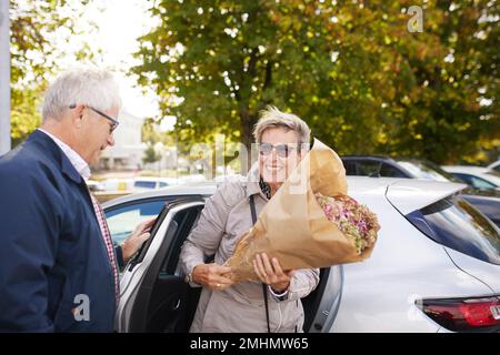 Coppia matura in piedi vicino all'auto Foto Stock