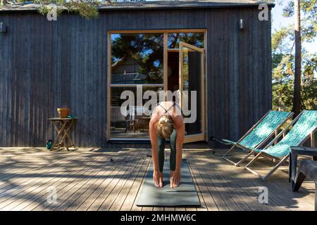 La donna a praticare yoga sul patio Foto Stock