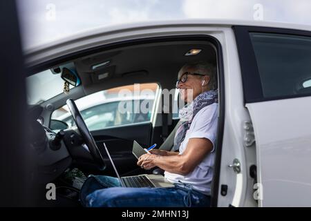 Donna sorridente seduto in auto Foto Stock