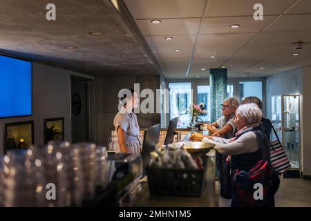 Addetto alla reception che assiste il cliente presso il centro benessere Foto Stock