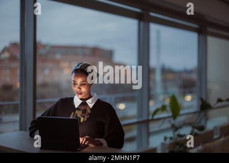 Giovane donna lavora sul computer portatile Foto Stock