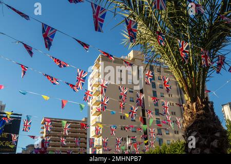 Palma e bandiere jack sindacali a Benidorm, Spagna Foto Stock