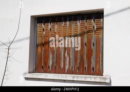 persiane arrugginite della vecchia casa sopra la parete bianca casa sulla facciata Foto Stock