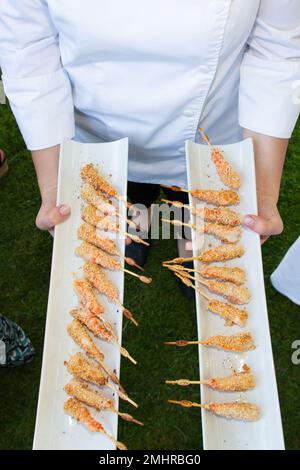 cameriere che tiene un piatto di antipasti in legno nel catering di nozze dell'evento della festa Foto Stock