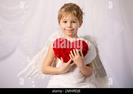 Piccolo toddle cupido ragazzo, tenere arco e freccia, bel cherubino biondo, amore Foto Stock