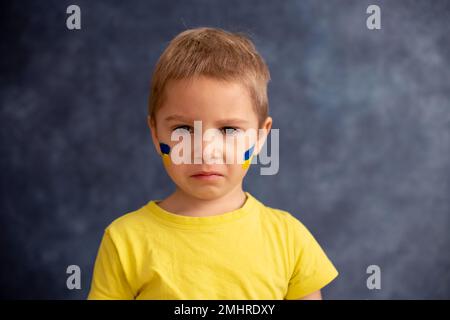 Bambino biondo giovane, segno di sostegno alla pace, nessuna guerra voluto, capretto che desidera la vita pacifica. Foto in relazione alla guerra in corso in Ukrain Foto Stock