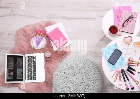 Vista dall'alto del luogo di lavoro del blogger di moda con laptop e cosmetici Foto Stock