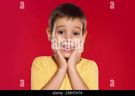 Ritratto del ragazzino emozionale su sfondo rosso Foto Stock