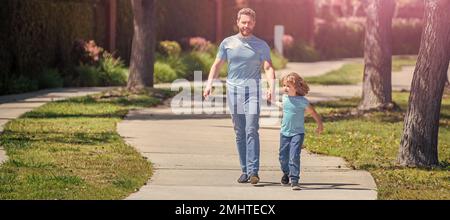 Banner di padre e figlio a piedi, allegro papà con bambino rilassarsi insieme nel parco, famiglia a piedi Foto Stock