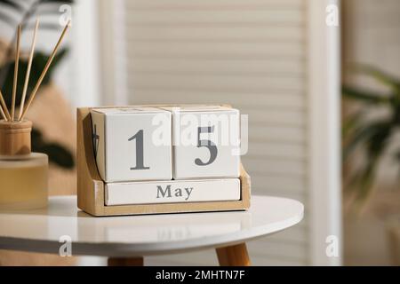 Calendario a blocchi in legno e profumatore d'aria a canna aromatica su tavolo bianco all'interno Foto Stock