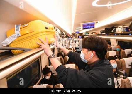 Chongqing. 27th Jan, 2023. Un passeggero mette i suoi bagagli sullo scaffale superiore su un treno alla stazione ferroviaria di Shapingba nel Chongqing, nel sud-ovest della Cina, il 27 gennaio 2023. Le stazioni ferroviarie, le autostrade e gli aeroporti di tutta la Cina sono in grado di offrire un nuovo picco di viaggi, mentre un numero crescente di viaggiatori si recano in viaggio e tornano al lavoro dopo una settimana di vacanza al Festival di primavera che termina il venerdì. Credit: Wang Quanchao/Xinhua/Alamy Live News Foto Stock