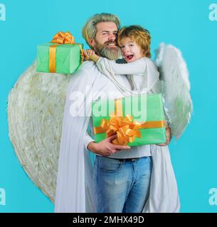 Piccolo angelo bambino e uomo bearded con dono. Angeli di padre e figlio in ali bianche. San Valentino. Foto Stock