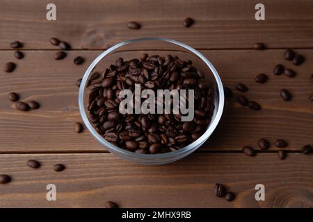 chicchi di caffè arrosto in un recipiente di vetro sul tavolo Foto Stock