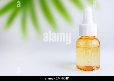 Bottiglia di vetro contagocce mock-up. Contenitore trasparente arancione con olio per viso, lozione o siero. Cosmetologia e concetto di bellezza, omeopatia e altern Foto Stock