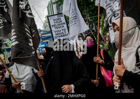 Kuala Lumpur, Malesia. 27th Jan, 2023. Un gruppo di donne appartenenti a gruppi islamici malesi è in possesso di cartelli e bandiere mentre partecipano a una marcia pacifica e si radunano davanti all'ambasciata olandese protestando contro la dissacrazione di un Corano da parte di un leader politico olandese a Kuala Lumpur. Protestavano contro Edwin Wagensveld, capo del capitolo olandese degli europei patrioti tedeschi contro l'islamizzazione dell'Occidente, abbreviato con Pegida, che strappava pagine del libro sacro islamico e le cavalcava all'Aia all'inizio di questa settimana. Credit: SOPA Images Limited/Alamy Live News Foto Stock