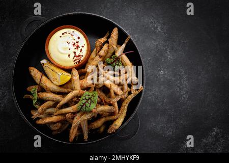 Pesce fritto con salsa, antipasto alla birra, su cemento grigio Foto Stock