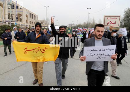 Teheran, Teheran, Iran. 27th Jan, 2023. Gli iraniani detengono il Quran e un cartello scritto ''obbediente al comando del mio leader'' durante una protesta contro l'incendio di un Corano a Stoccolma, dopo aver recato la preghiera del venerdì alla Moschea Imam Khomeini a Teheran, in Iran, il 27 gennaio 2023. Rasmus Paludan, politico di estrema destra svedese-danese, ha dato fuoco a una copia del libro sacro musulmano di fronte all'ambasciata turca nella capitale svedese. Molti paesi musulmani hanno detto di essere indignati per l'incendio del Corano, che il primo ministro svedese Ulf Kristersson ha condannato come 'fortemente irrispettoso' (Credit Image: © C Foto Stock