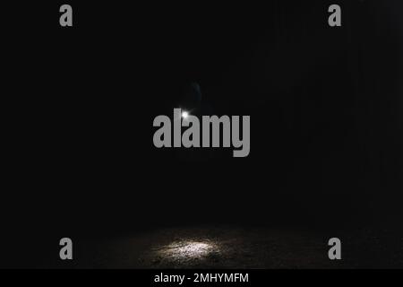 Silhouette dell'uomo con torcia luminosa nella foresta di notte Foto Stock