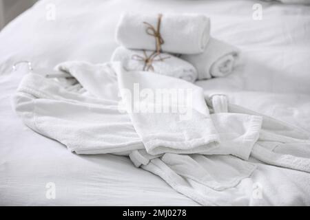 Accappatoio e asciugamani puliti e morbidi sul letto Foto Stock