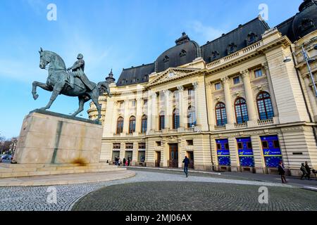 Bucarest, Romania, 2 gennaio 2022: La Biblioteca Universitaria Centrale (Biblioteca Centrala Universitaria) e il monumento del Re Carol i in Revolutiei Squar Foto Stock