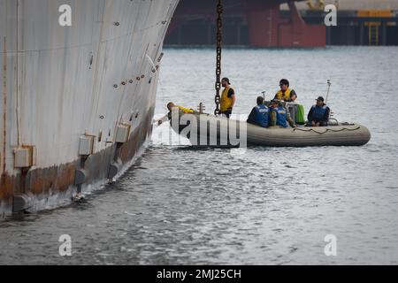 STATI UNITI Brandon Haschke, Senior Chief Maintenance della Marina militare (a sinistra, inclinata), posiziona un potente magnete sullo scafo a dritta della nave da test autodifesa (SDTS) per preparare una dimostrazione il 24 agosto, il terzo giorno dell'esercizio sulla tecnologia di riparazione, O REPTX, al Naval Surface Warfare Center, Port Hueneme Division (NSWC PHD). Due aziende in seguito hanno implementato dei robot per cercare oggetti estranei nello scafo. Foto Stock