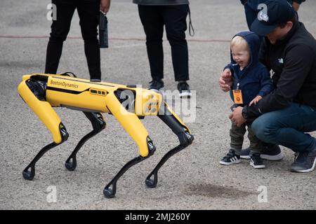 Il Naval Surface Warfare Center, Port Hueneme Division (NSWC PHD) Research Manager Jason Bickford (a destra) dà a suo figlio di 2 anni Jack un'occhiata da vicino al robot di ispezione spot di Boston Dynamics al Repair Technology Exercise, o REPTX, al NSWC PHD il 24 agosto. Tramite il telecomando di un operatore vicino, il robot simile a un cane visualizzava movimenti complessi. Foto Stock