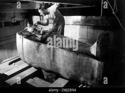 Tomba di Tutankhamon. Howard carter che esamina il sarcofago dalla tomba del re Tutankhamon, Luxor, Egitto. Fotografia presa c. 1925 di Harry Burton(1879-1940) Foto Stock