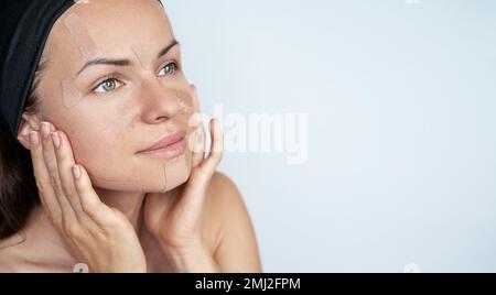 Concetto di bellezza viso cura della pelle donna applicando cinesiologia nastri facciali sul viso, terapia anti rughe. Foto Stock