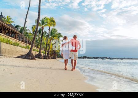 Coppia innamorata mentre cammina su una spiaggia sabbiosa esotica. Hanno una passeggiata serale sul mare di Trou-aux-Biches sull'isola di Mauritius. Persone relati Foto Stock